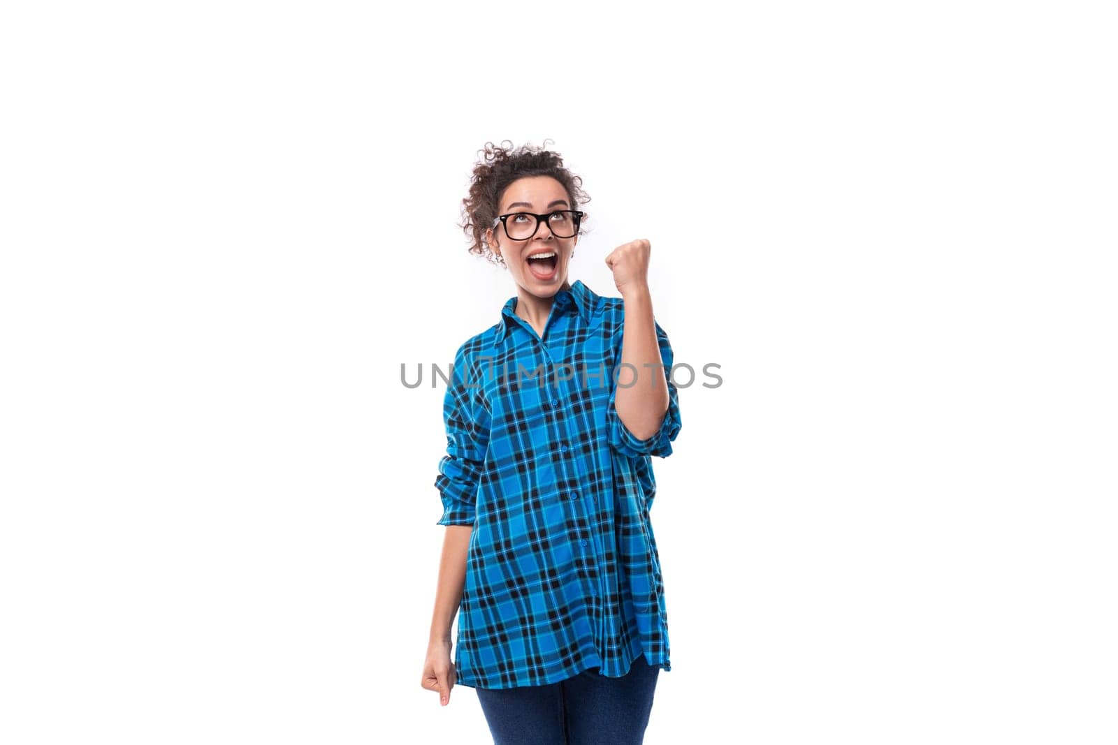 young smiling energetic curly european woman dressed casually in a blue plaid shirt on a white background.
