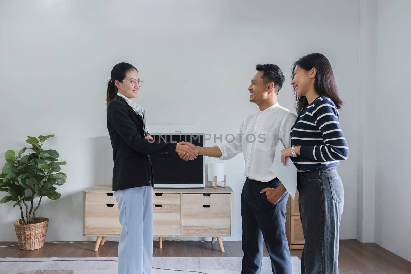 A real estate agent or broker shake hands with his client after completing a deal. at the sample house by wichayada