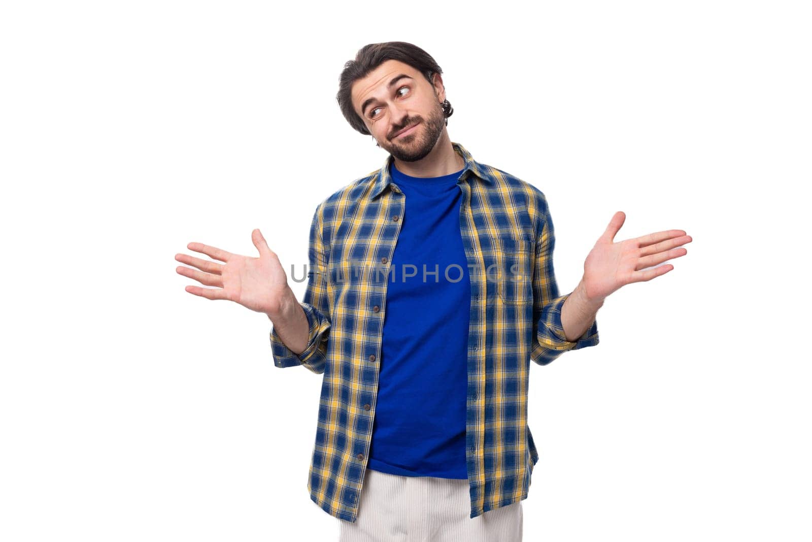 a young caucasian brunette man with a beard and an earring is dressed in a blue plaid shirt and t-shirt actively gesticulates and points with his hands by TRMK