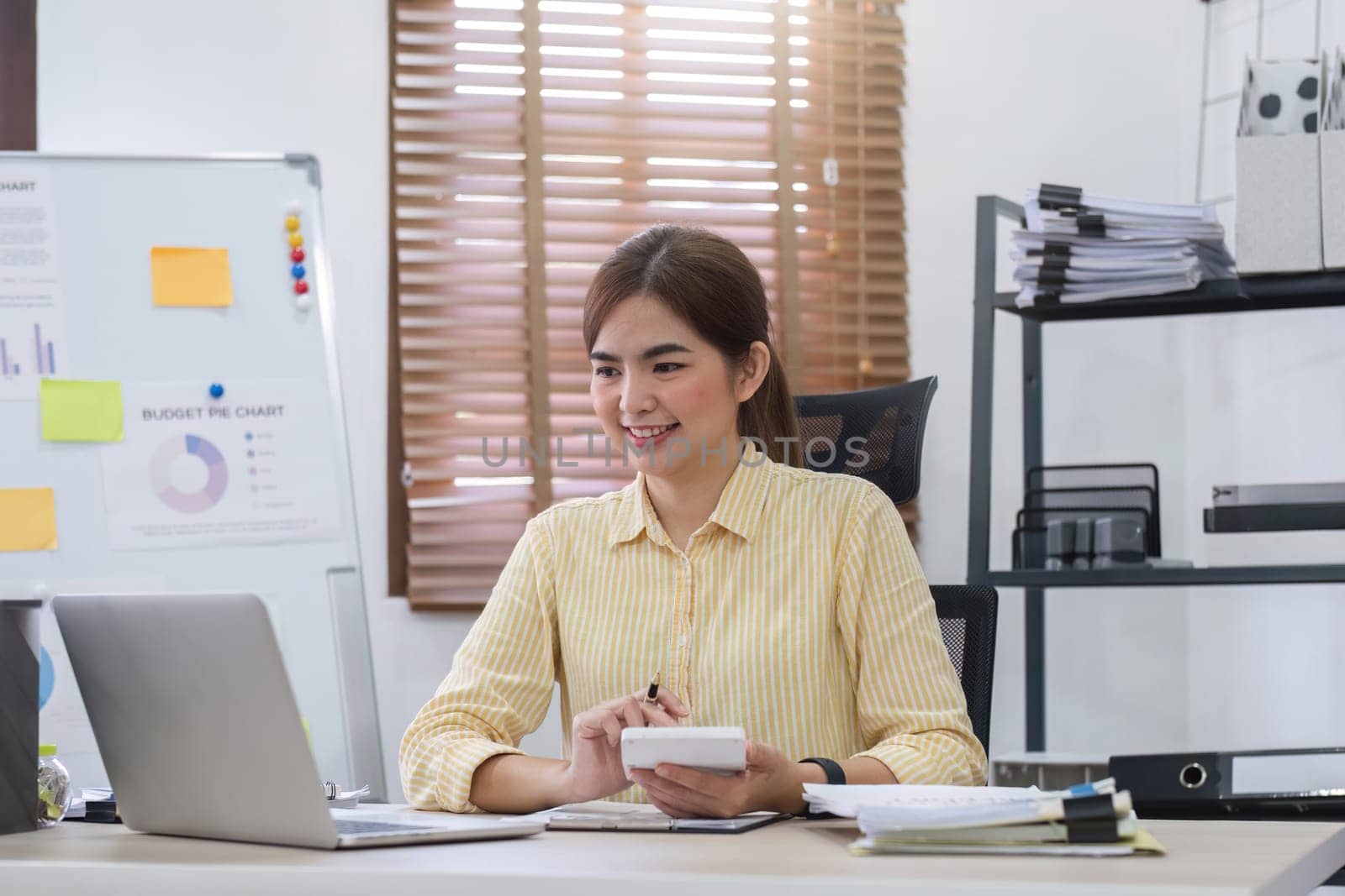 Businesswoman uses calculator to calculate finances, mathematics on table in office and business charts, tax, accounting, statistics and analytical research concept..