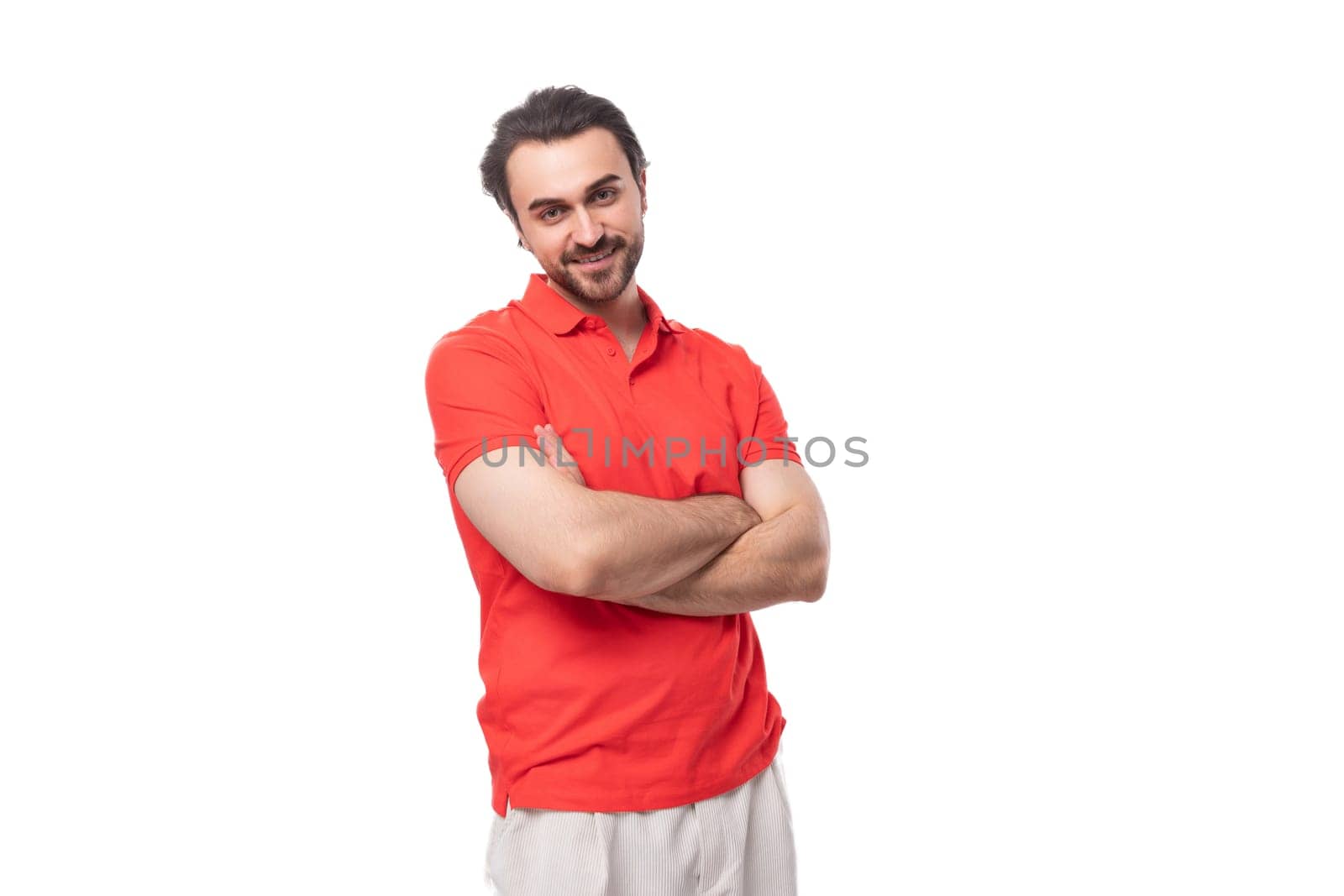 young brutal 35 year old european man with a well-groomed haircut and beard in a red t-shirt.