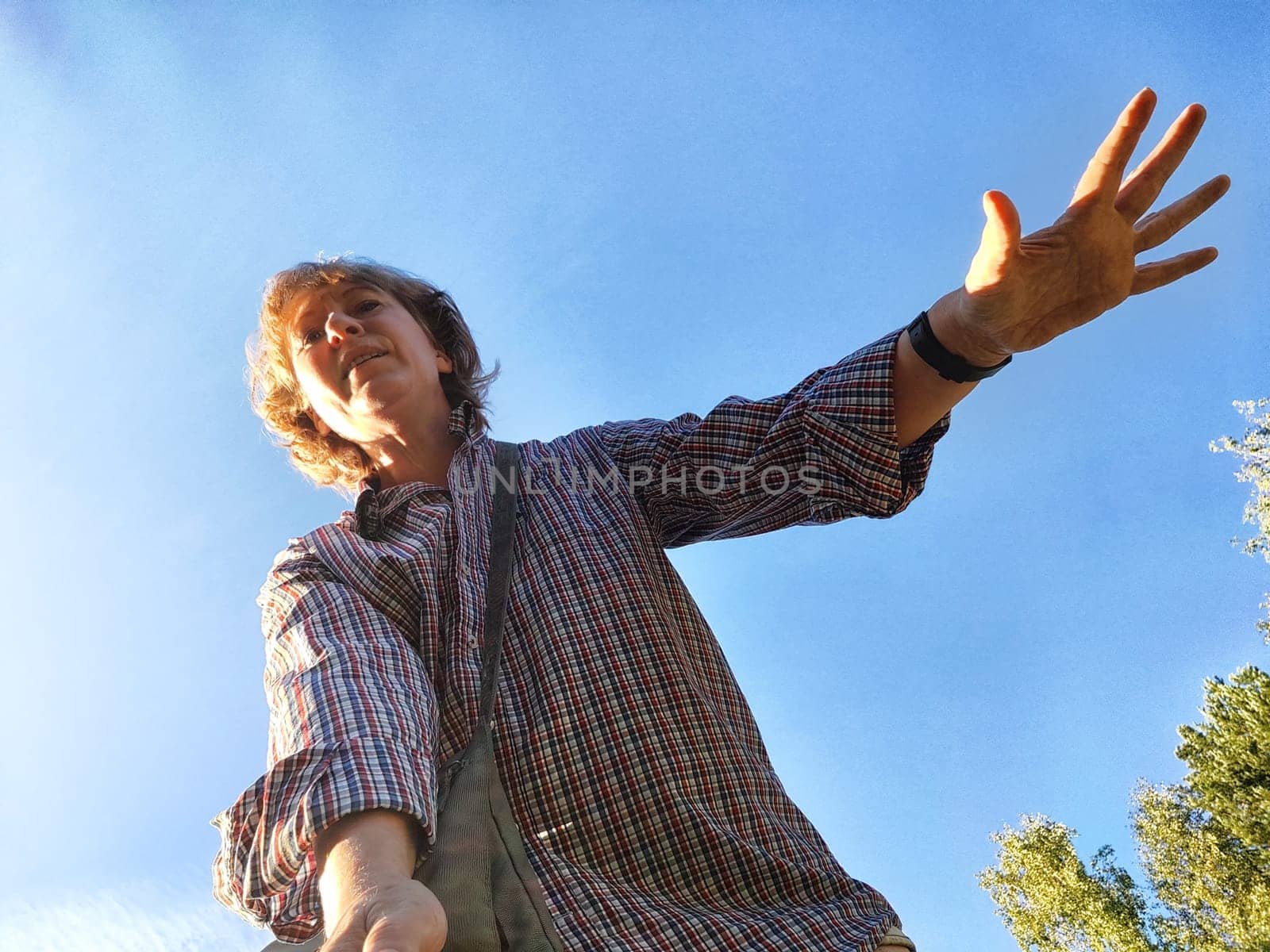Funny adult girl posing in nature. A middle-aged woman takes a selfie in the landscape. City tourist on vacation on picnic