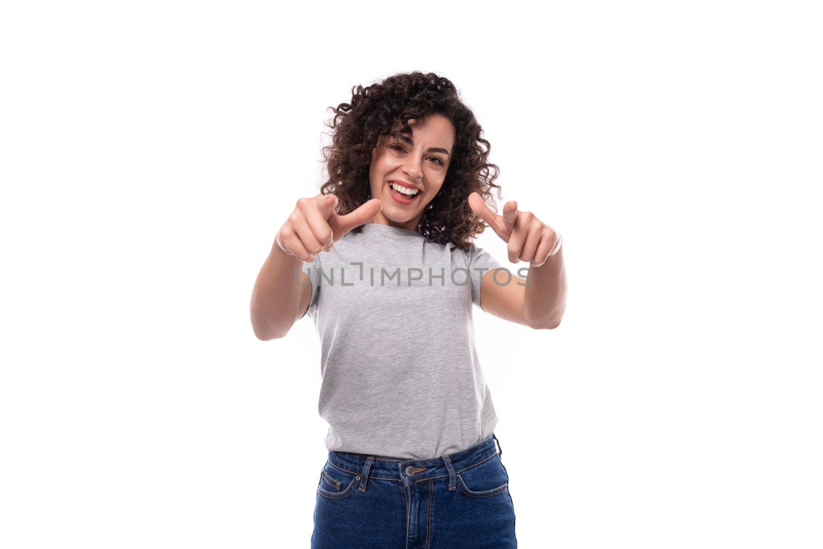 positive slim curly brunette promoter woman with glasses is dressed in a gray basic t-shirt with an identity print mockup on a white background with copy space by TRMK
