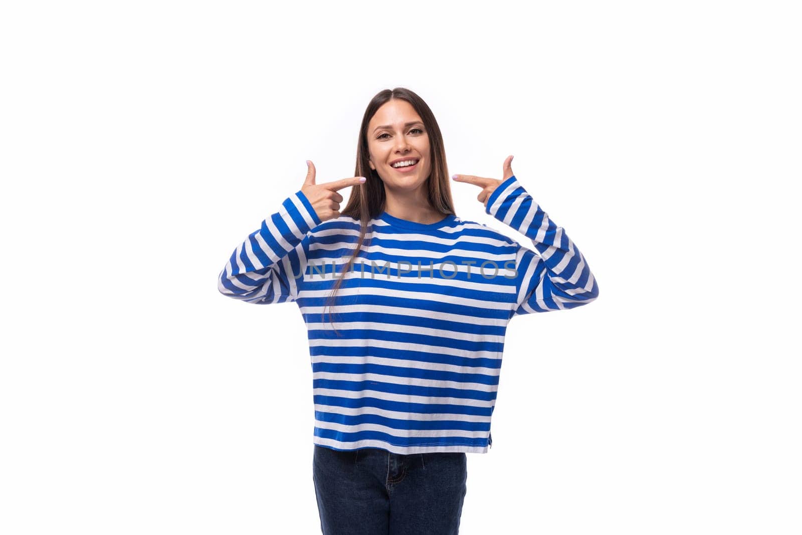 positive smiling young brunette woman in a striped blue blouse on a white background with copy space.