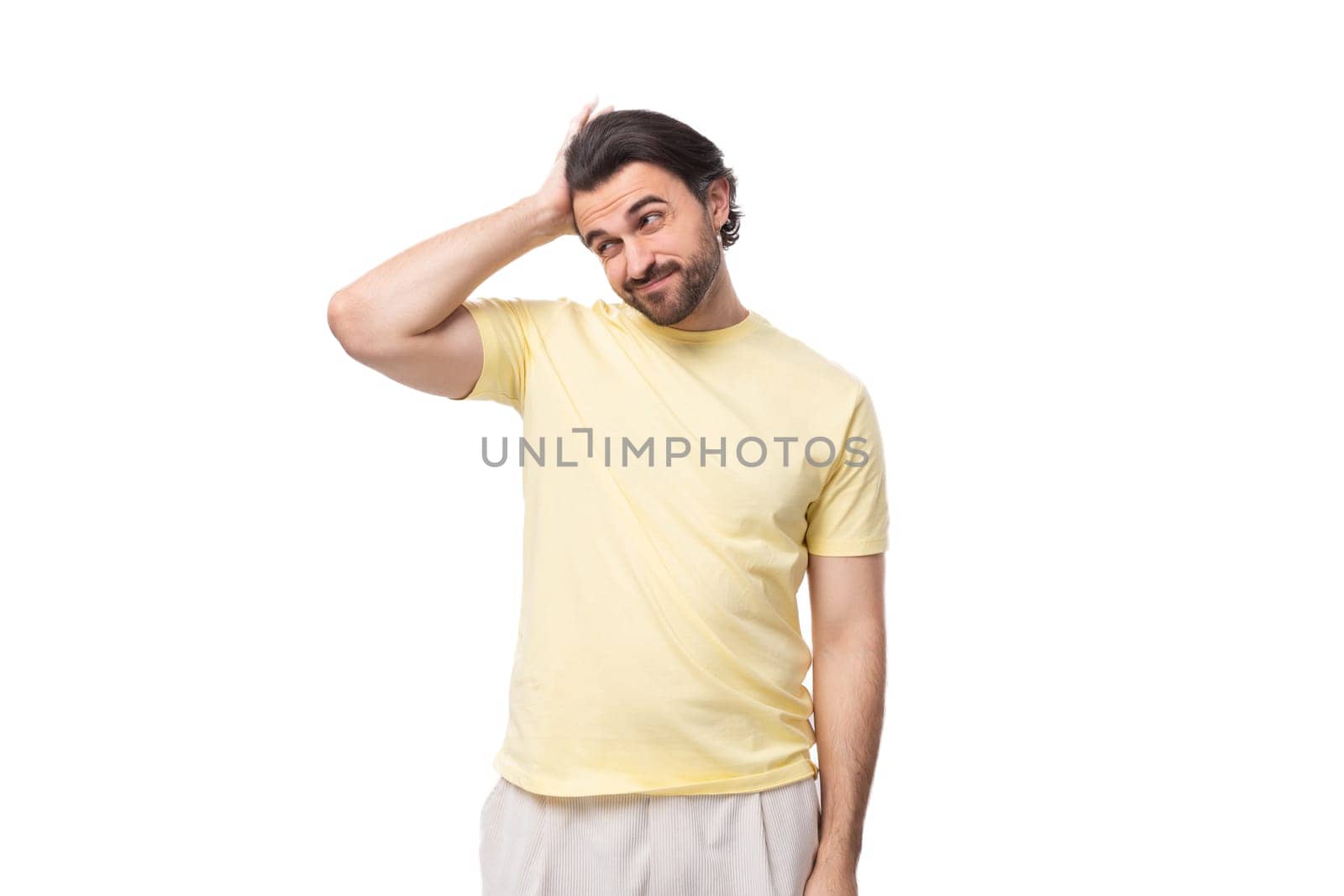portrait of a pensive stylish brunette european man with a beard and mustache dressed in a summer t-shirt.
