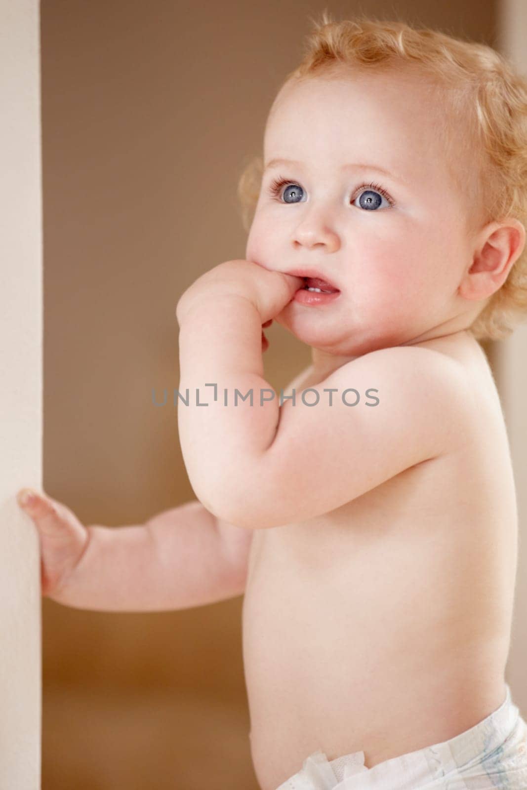 Face, hands and baby in a room for playing, watching or fun, learning, walk or balance. Little, child development and curious boy kid in a nursery playful, standing and enjoy youth, freedom or games.