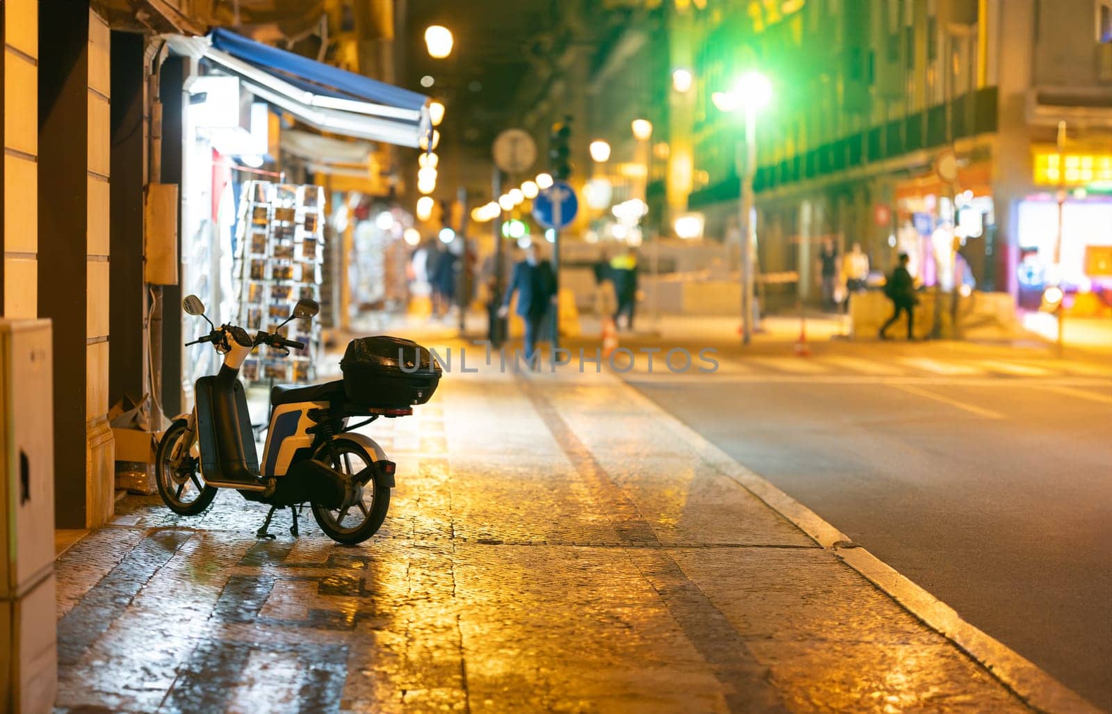 A motor scooter parked on the night street - copy space