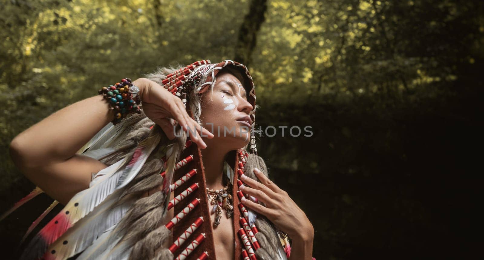 the portrait of a young girl in Native American Headdresses against the background of nature
