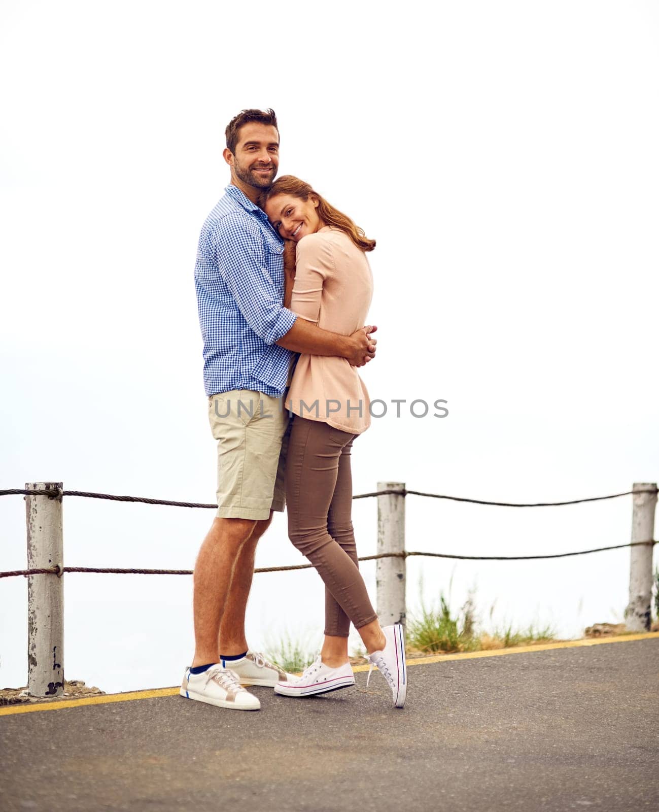 Couple, hug and smile in portrait, outdoors and vacation or holiday, romance and date together. Happy people, freedom and embrace on street, travel and explore for tourism, love and carefree or joy.