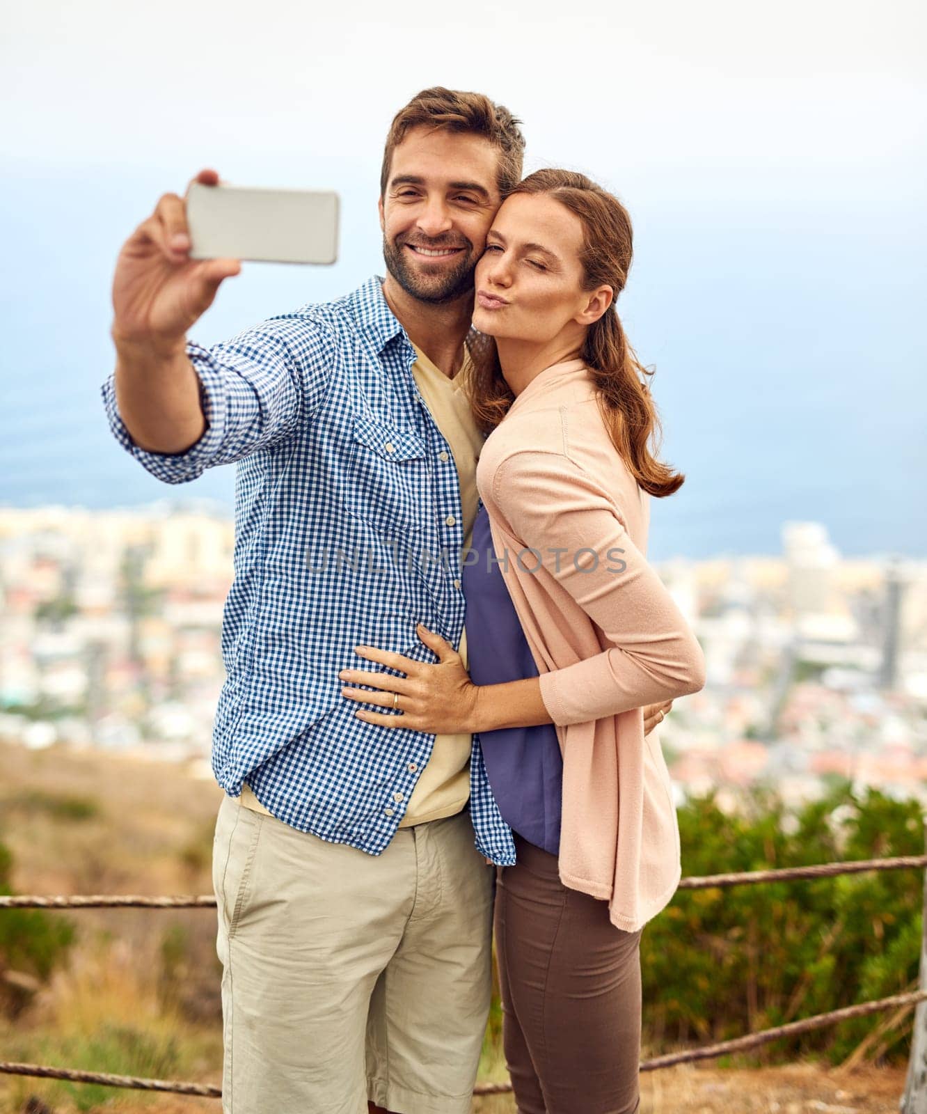 Couple, hug and selfie on vacation, phone and outdoors on adventure, love and memories for social media. Happy people, smartphone and bonding or technology, travel and holiday or pout on date by YuriArcurs
