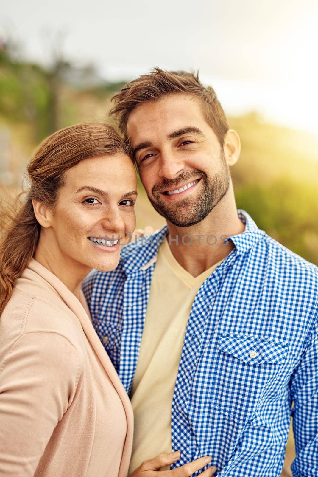 Couple, hug and smile in portrait, nature and vacation or holiday, romance and date together. Happy people, freedom and embrace in outdoors, travel and explore for tourism, love and carefree or joy.