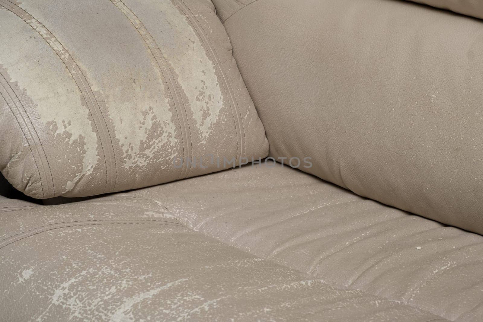 Defects on a white leather sofa. Damaged to leather furniture. by AnatoliiFoto