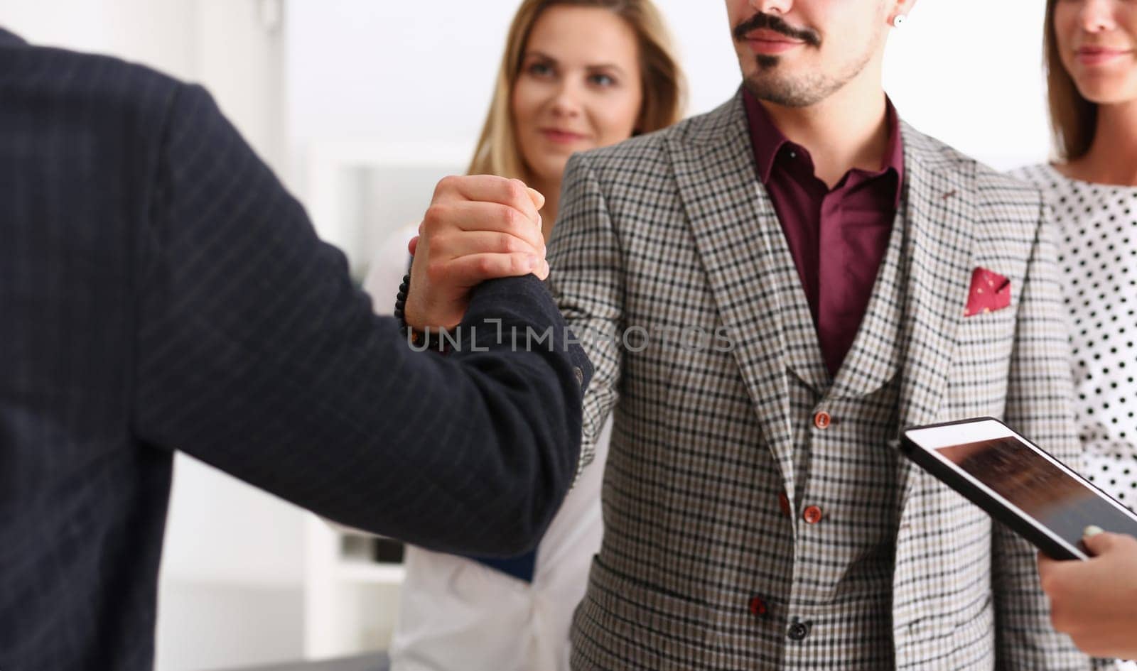 A helper of an Arab businessman organized a meeting with an investor for him, they shake hands with each other and anticipate the profits from joint actions interpreter escort service