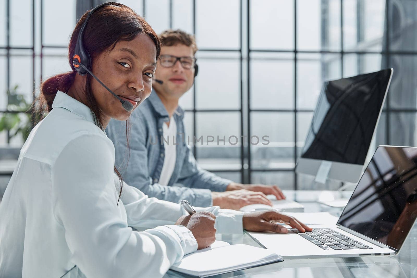 friendly operator woman agent with headsets working in a call center