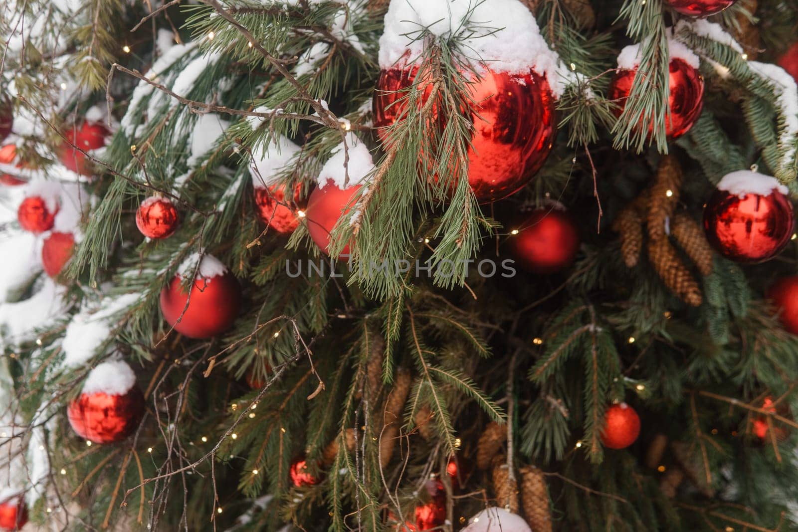 Christmas trees decorated with red balloons in front of the cafe entrance. Street Christmas decorations