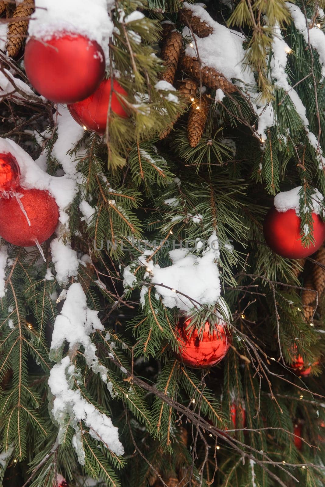 Christmas trees decorated with red balloons in front of the cafe entrance. Street Christmas decorations