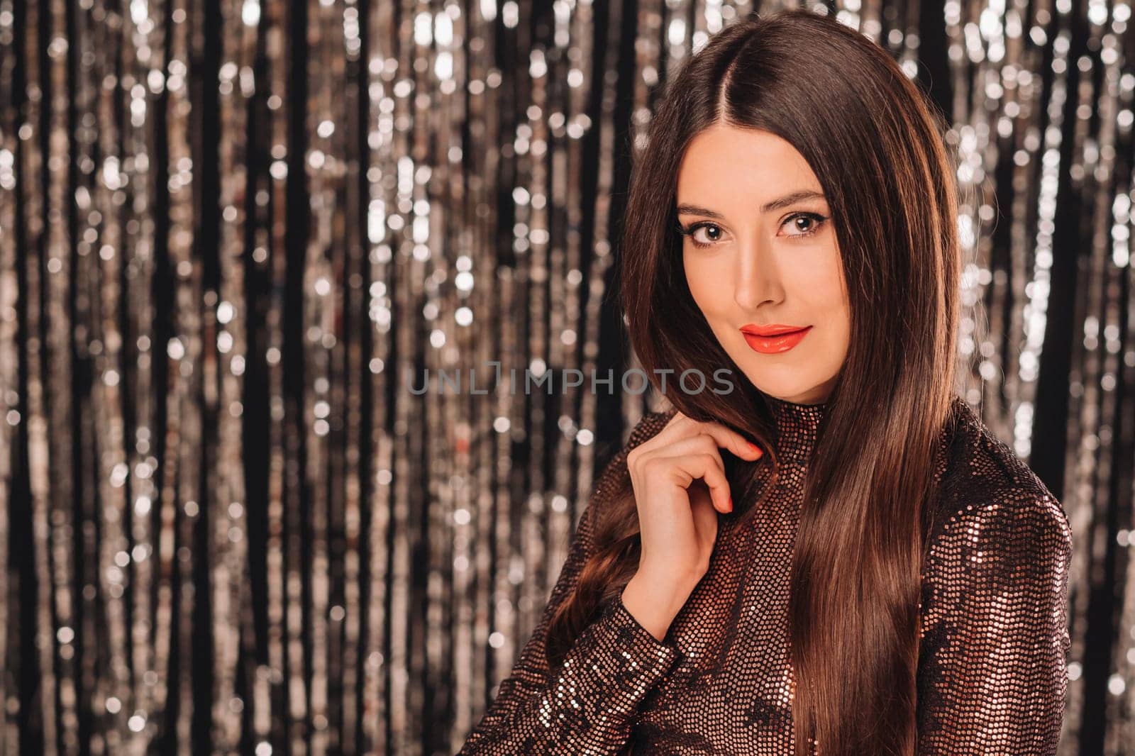 a girl in a shiny jacket on a silver background of New Year's rain.