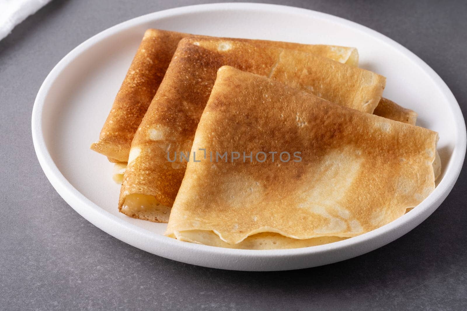 Plate with thin pancakes on table.