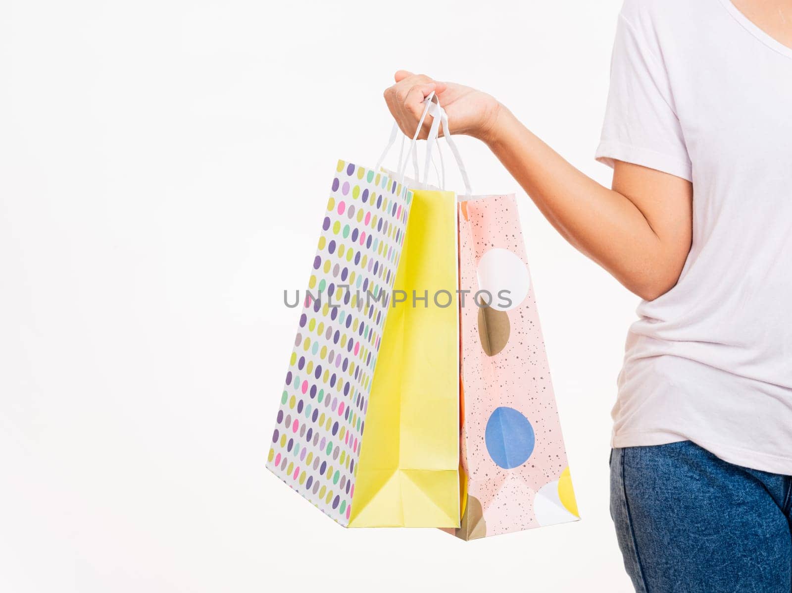 female holds in hand with multicolor clear empty blank craft paper gift bag by Sorapop