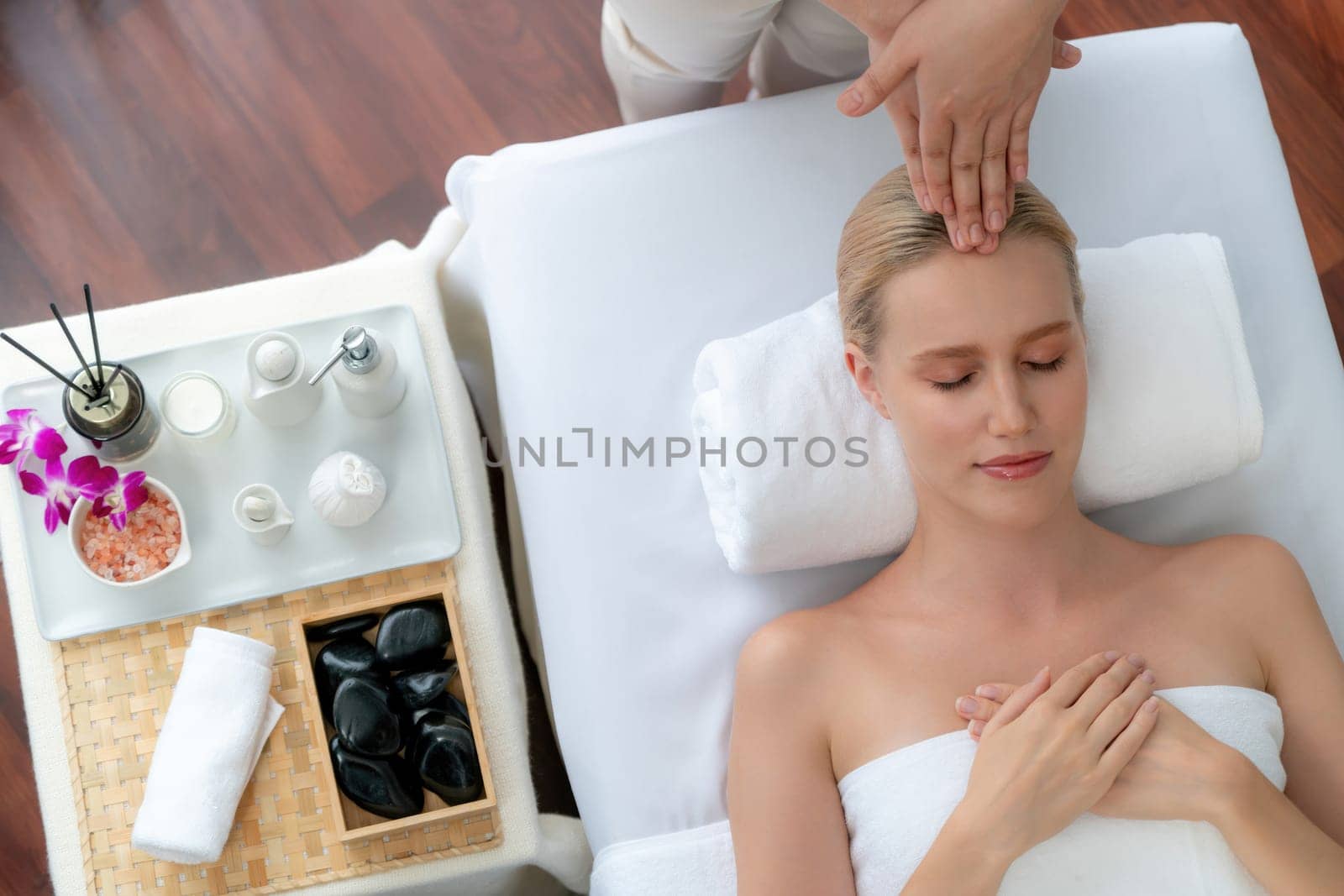 Panorama top view of woman enjoying relaxing anti-stress head massage and pampering facial beauty skin recreation leisure in dayspa modern light ambient at luxury resort or hotel spa salon. Quiescent