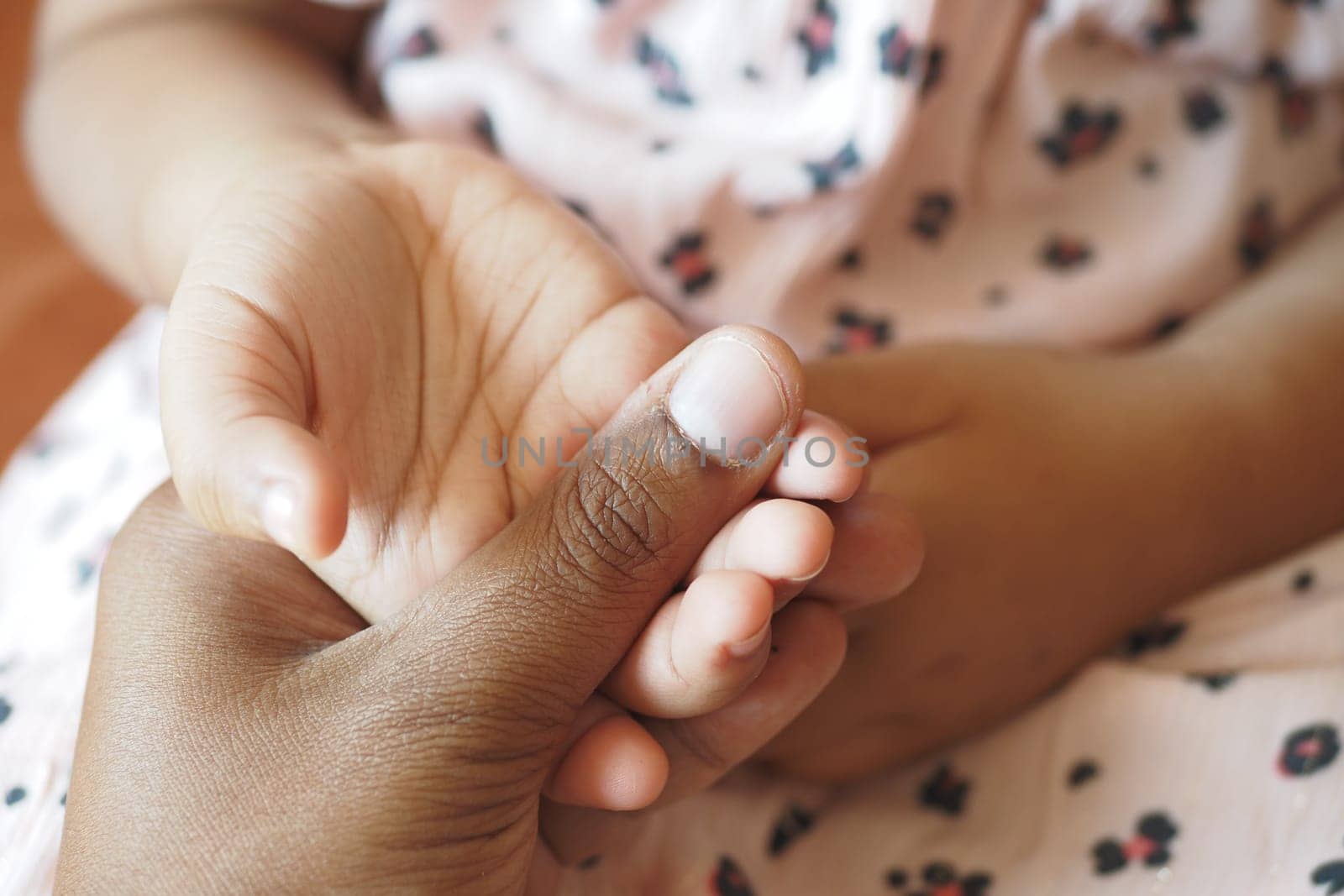 father holding hand of baby child, close up