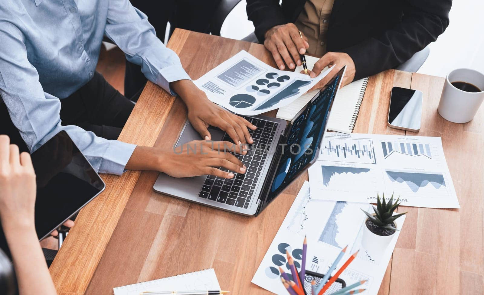 Multiracial analyst team use BI Fintech software to analyze financial data on meeting table. Financial dashboard data display on laptop screen with analyzed chart for marketing indication. Concord