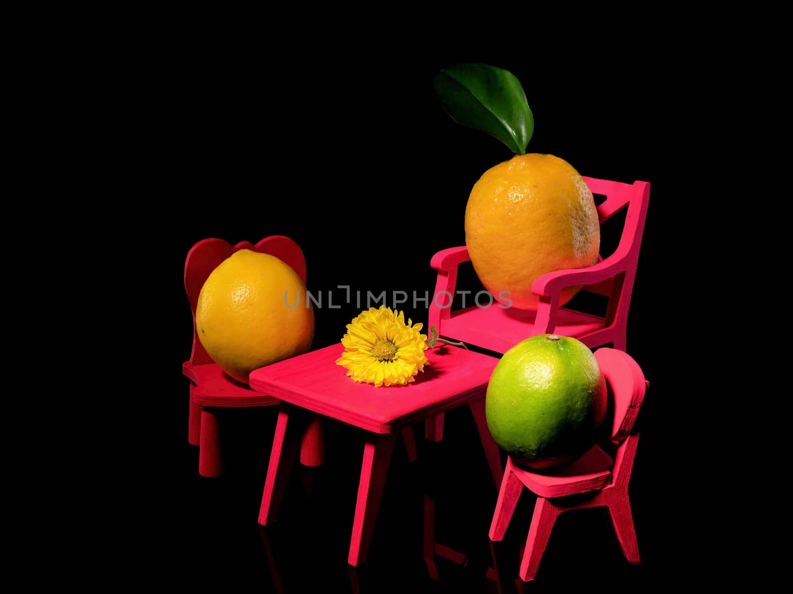 Creative still life with three lemons at the table with a flower on a black background