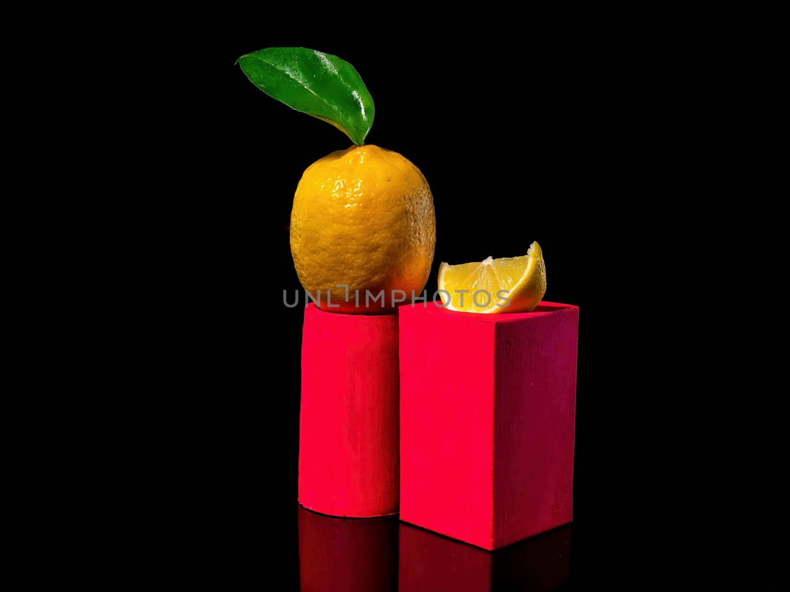 Creative still life Composition with lemon and a slice of lemon on a stand on a black background