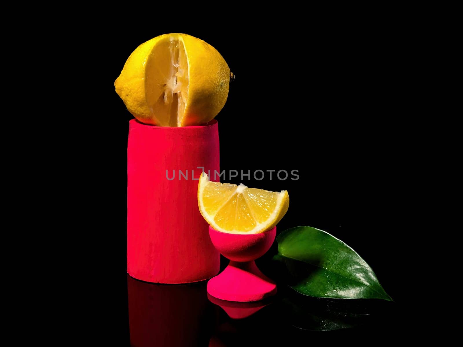 Creative still life Composition with lemon and a slice of lemon on a stand on a black background