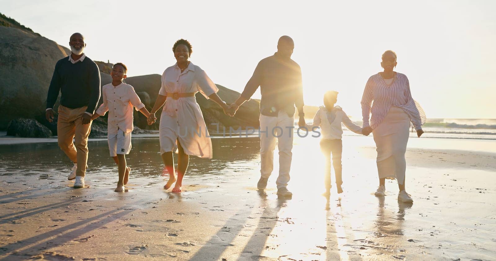 Family, fun and holding hands at beach, support and unity or trust, ocean and solidarity or care. Happy black people, sea and love or joy, bonding or water on vacation, holiday and laughing at sunset.