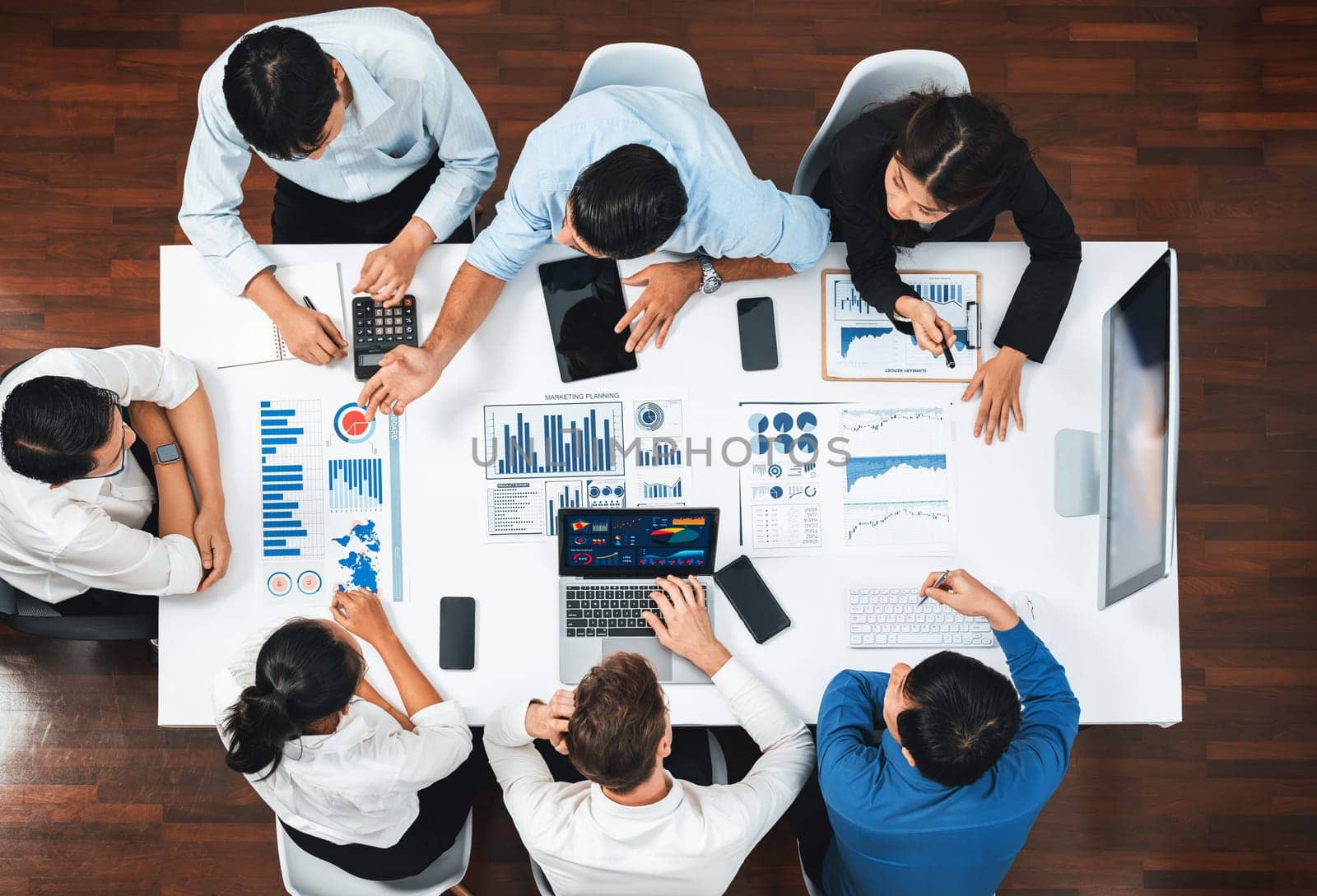 Top view analyst team utilizing BI Fintech to analyze financial data at table in meeting room. Analytic BI dashboard power on paper for business insight and strategic marketing planning. Prudent