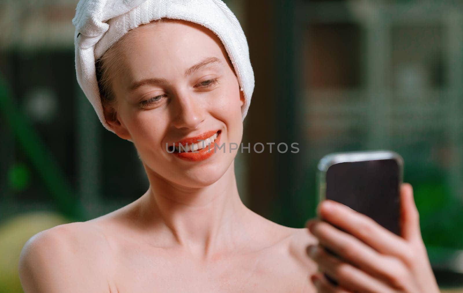 Portrait of close up beautiful caucasian woman in white towel taking video of calm and relaxing nature by using her mobile phone. Pretty girl with beautiful skin take photo. A Side view. Tranquility.