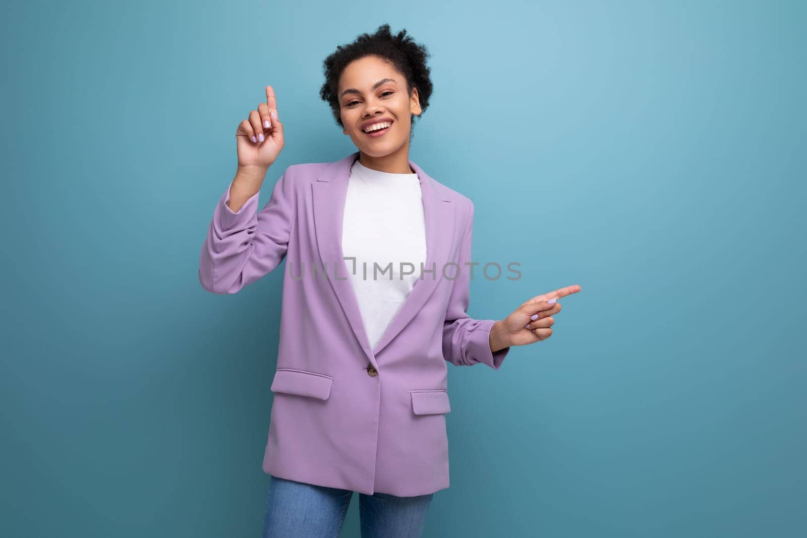 young positive cheerful hispanic business woman with curly hair dressed in an office stylish jacket.