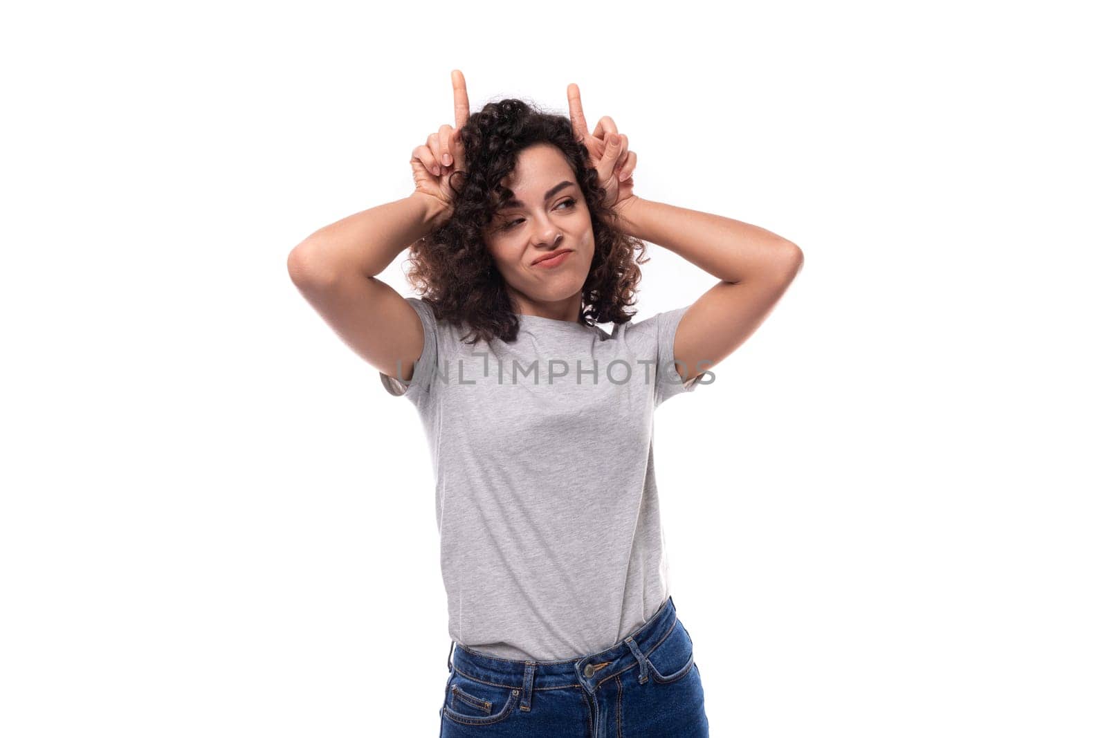 active bright curly woman with black hair dressed in a casual gray t-shirt with an identity print mockup on a white background with copy space.