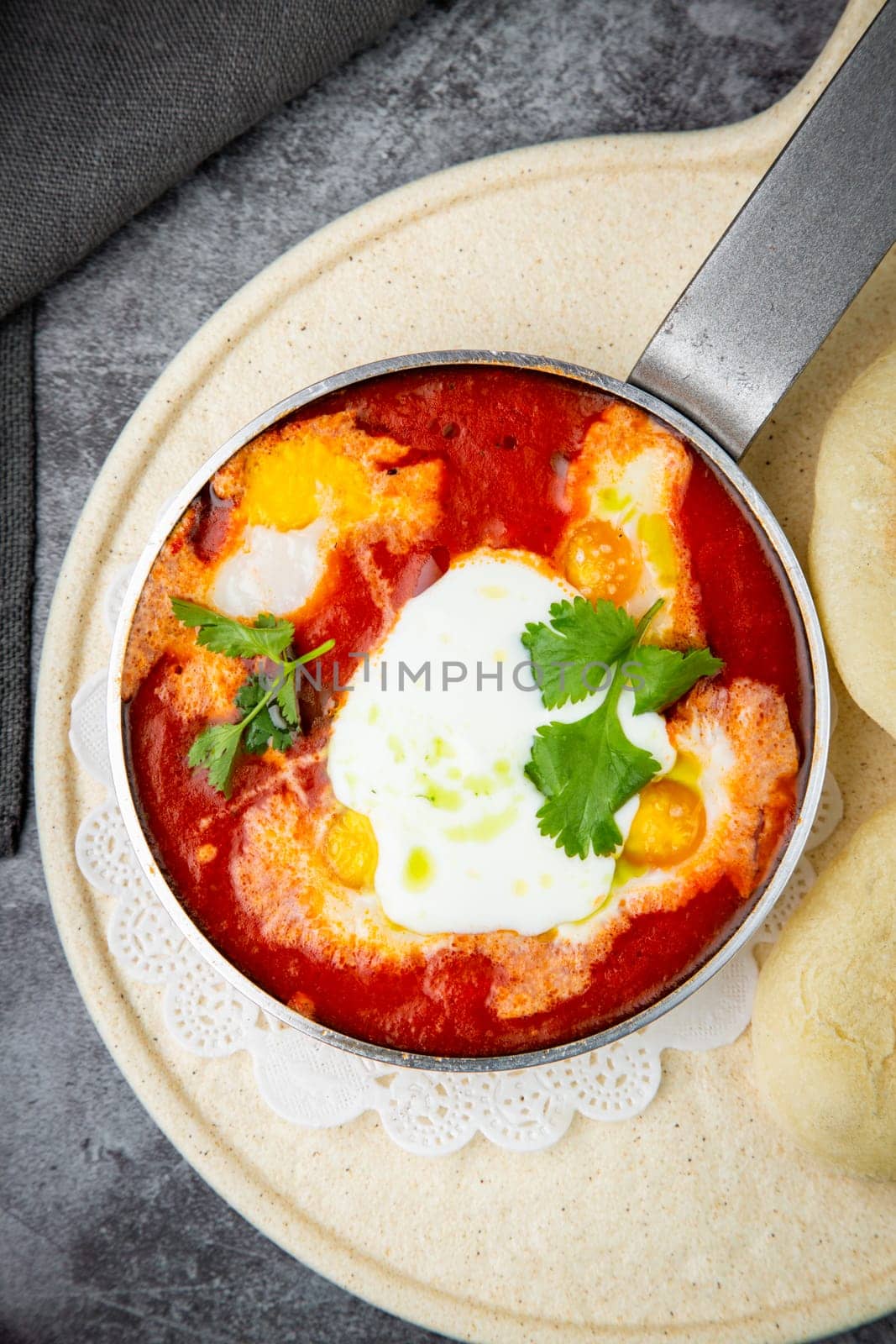 borscht in a frying pan with fresh flatbreads and cherry tomatoes top view by tewolf