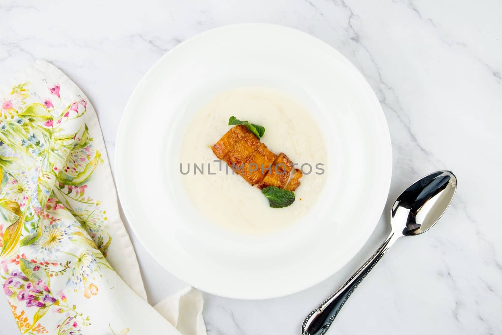 porridge with mint leaves and pieces of meat in sweet and sour sauce