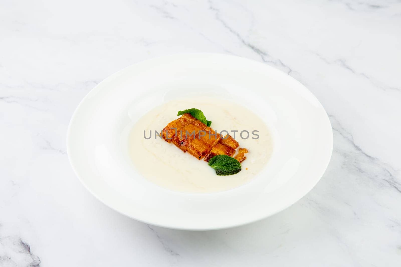 side view of porridge with mint leaves and pieces of meat in sweet and sour sauce by tewolf