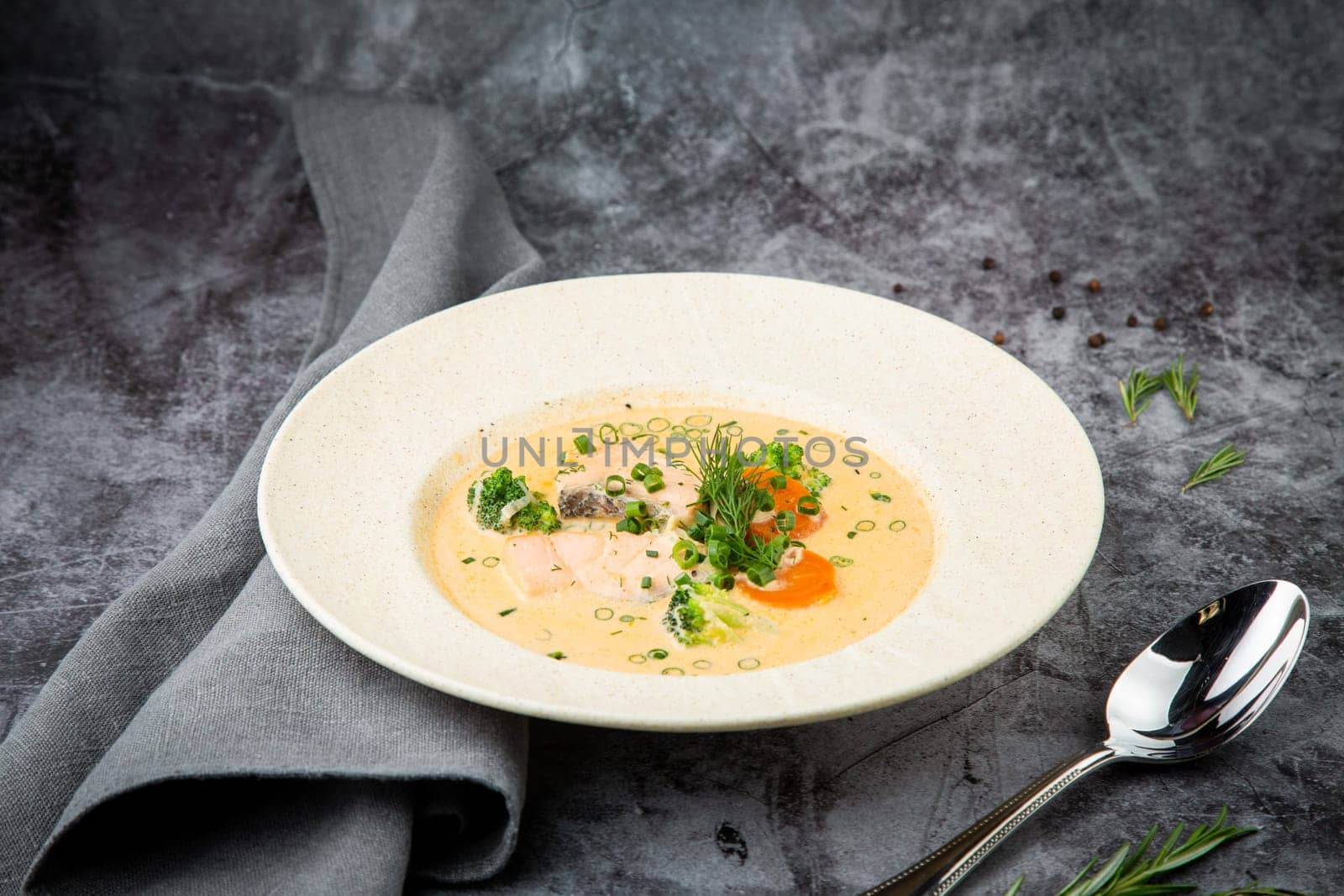 Scandinavian fish soup with herbs on a white plate side view by tewolf