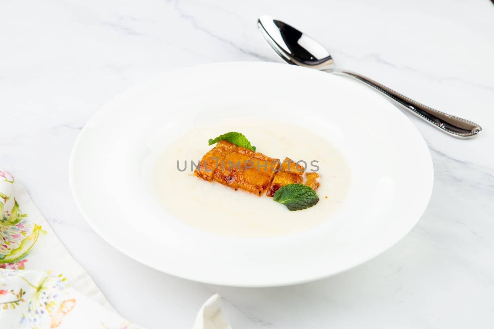 porridge with mint leaves and pieces of meat in sweet and sour sauce