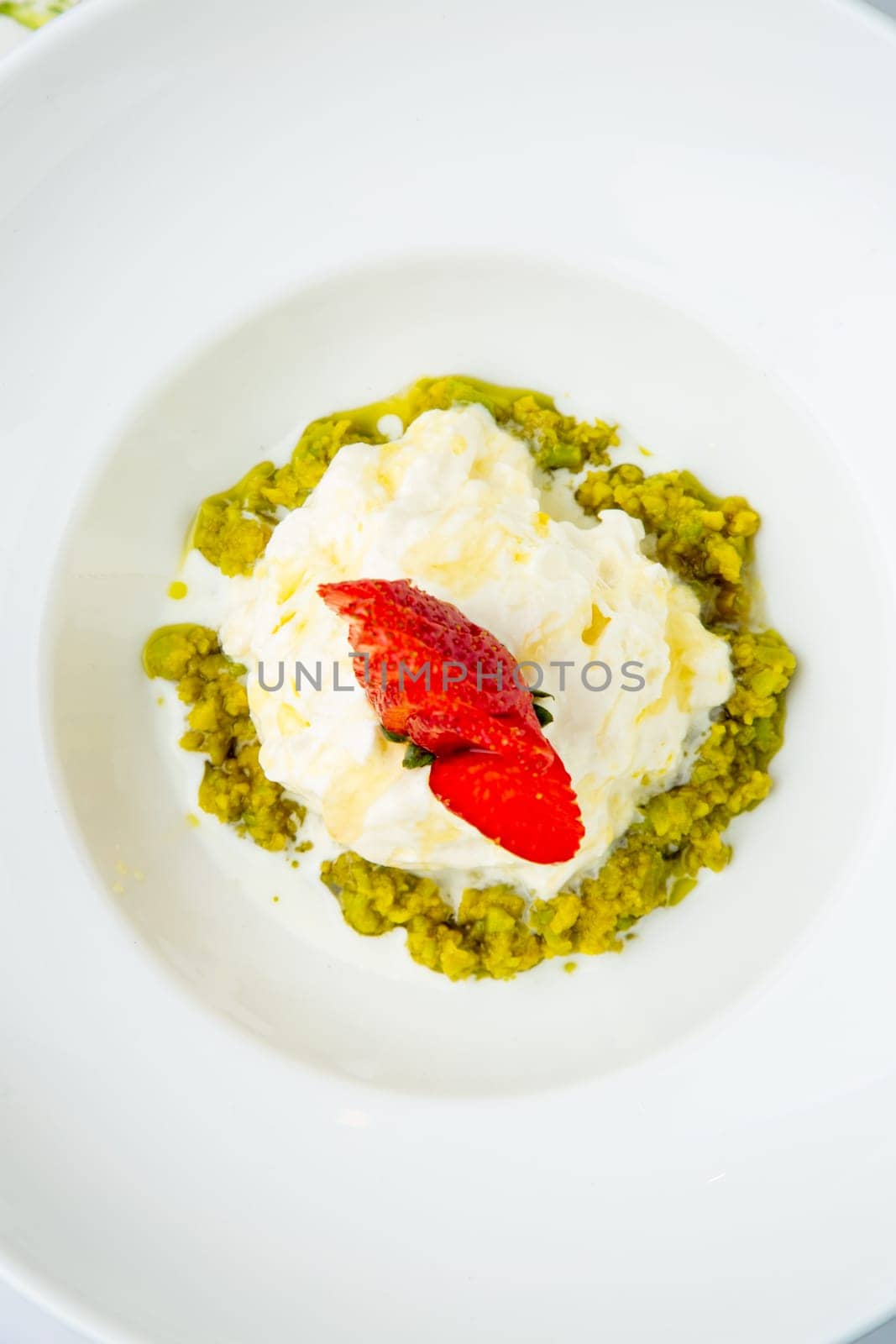 curd dessert with strawberries on top in a white plate on a marble background, top view by tewolf