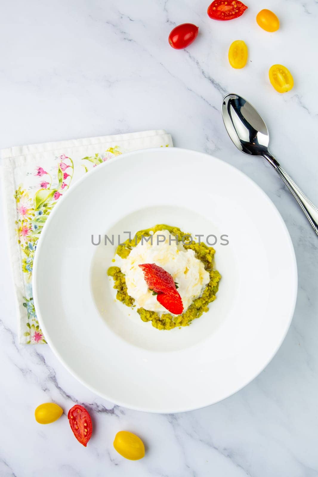 curd dessert with strawberries on top in a white plate on a marble background, top view by tewolf