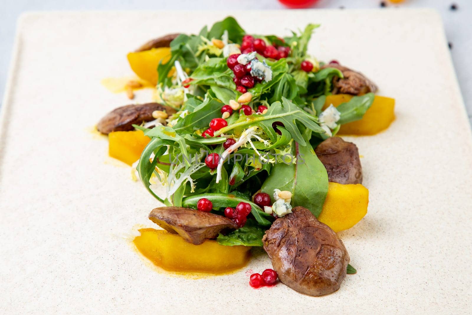 meat medallions with arugula, peach slices and red berries, side view by tewolf