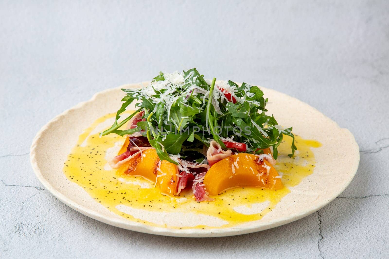 green salad with arugula and lingonberries on a white plate and marble background top view by tewolf