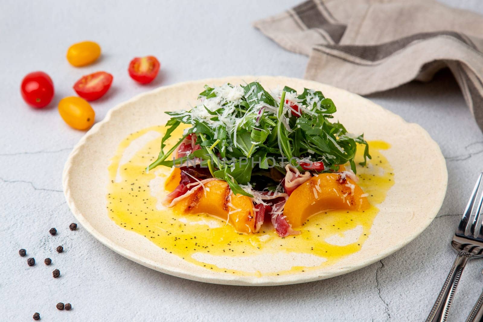 green salad with arugula and lingonberries on a white plate and marble background