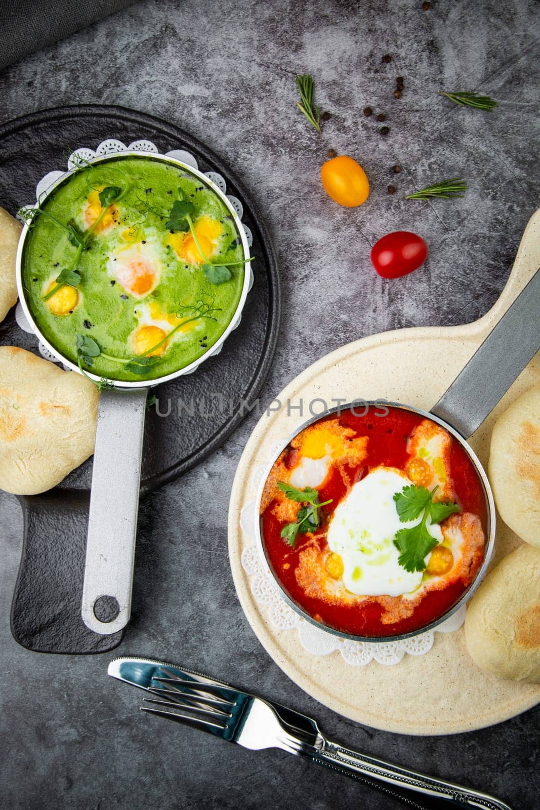 borscht in a frying pan with fresh flatbreads and cherry tomatoes