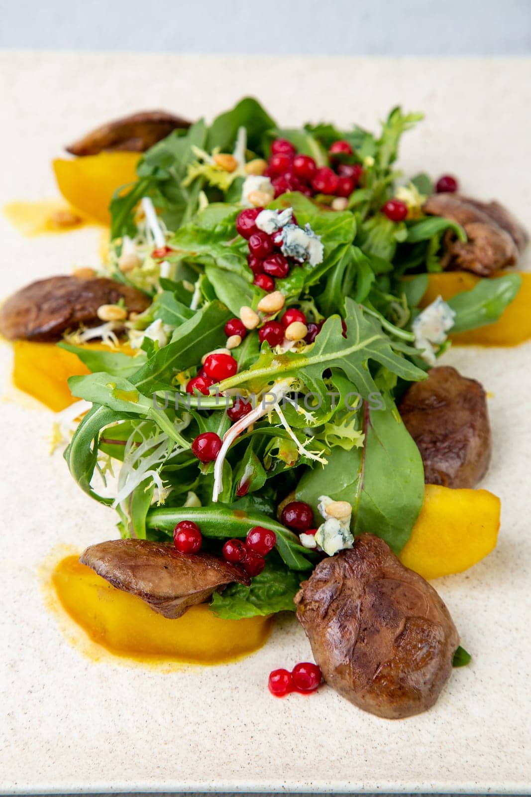 meat medallions with arugula, peach slices and red berries, side view by tewolf