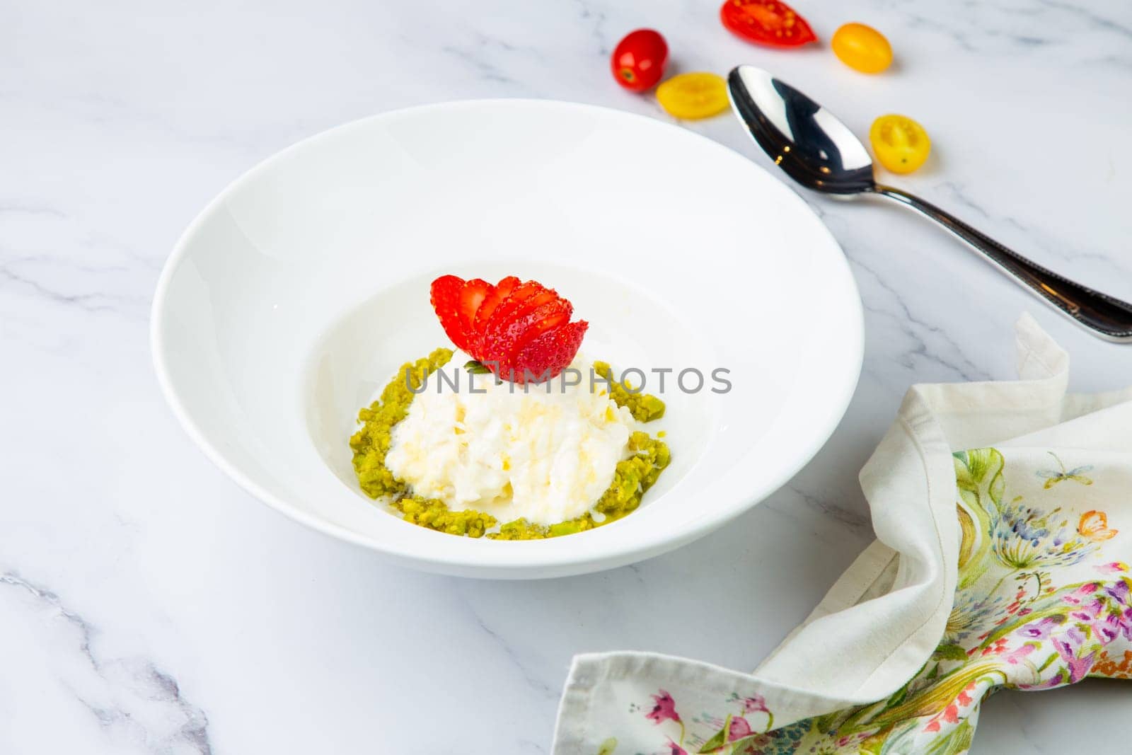 curd dessert with strawberries on top in a white plate on a marble background, side view by tewolf