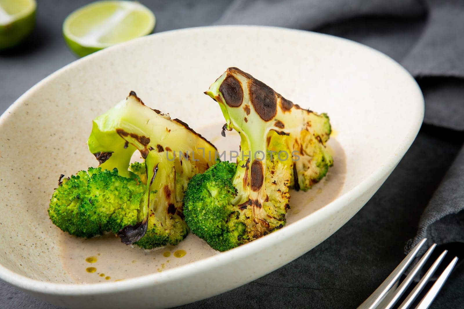 baked broccoli in mushroom sauce on a white plate