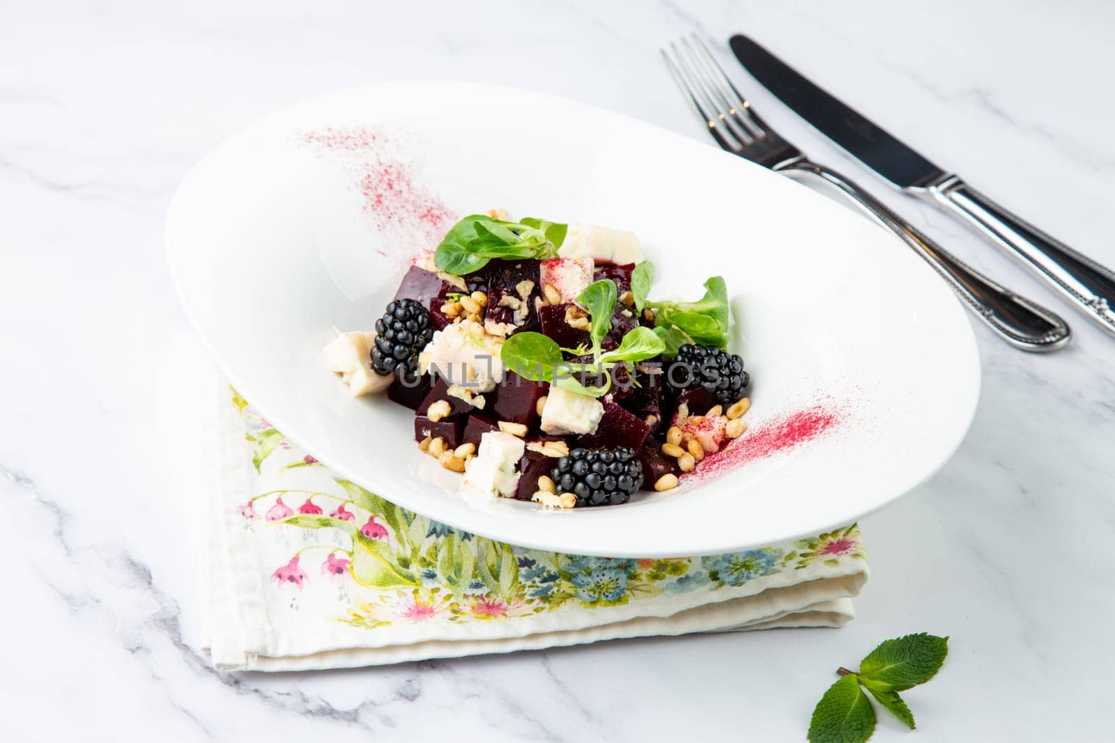 salad of blackberries, beets, seeds and cheese, side view on a white plate by tewolf