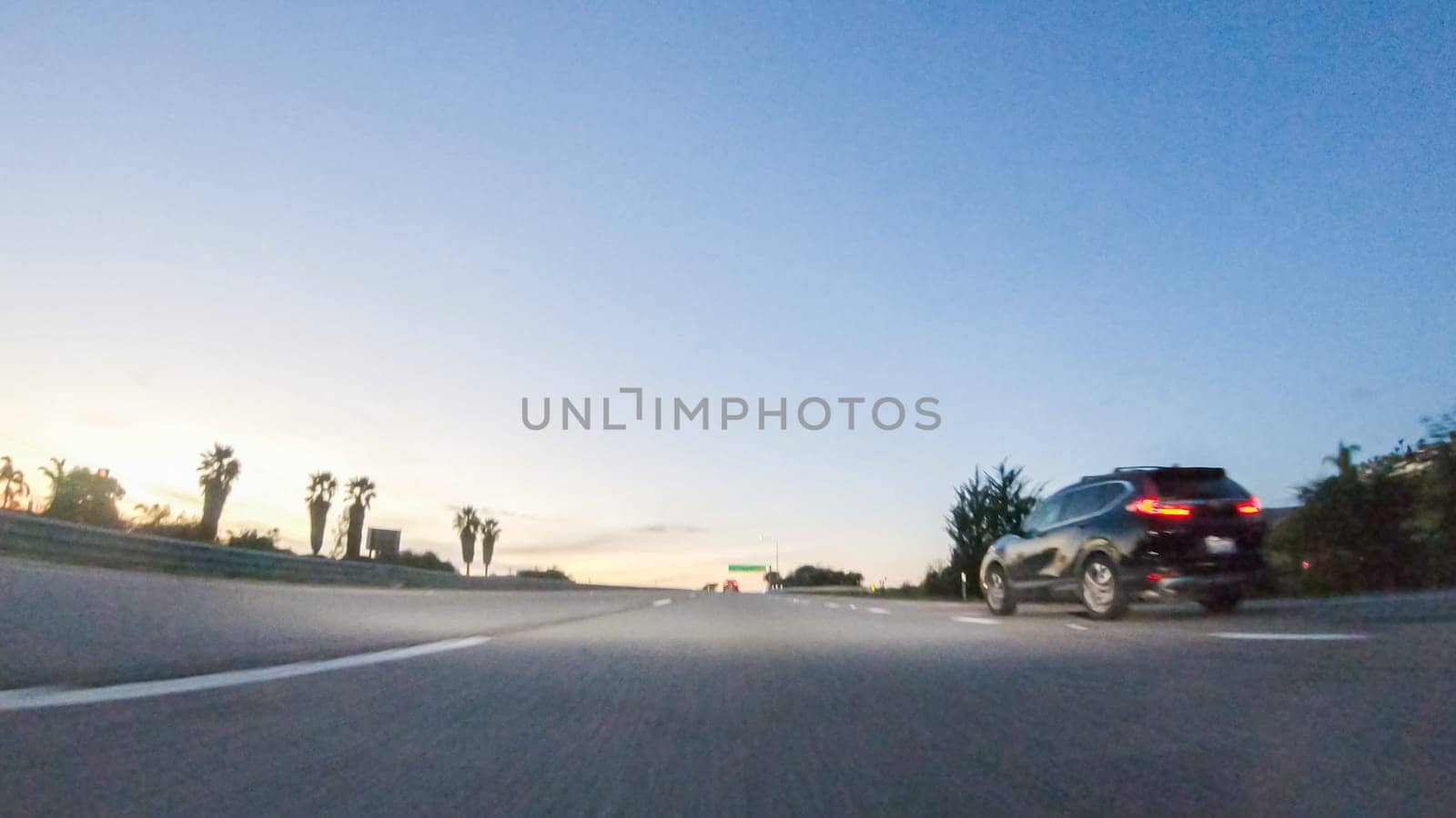 Los Angeles, California, USA-December 4, 2022-POV-As the sun sets, driving on HWY 101 near Pismo Beach, California becomes a captivating experience with the sky painted in shades of orange and pink, casting a warm glow over the coastal landscape.